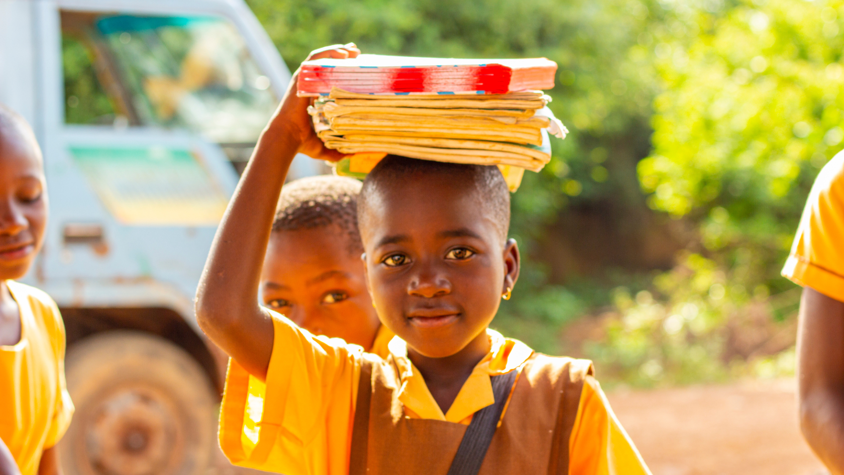 Child holding books on head